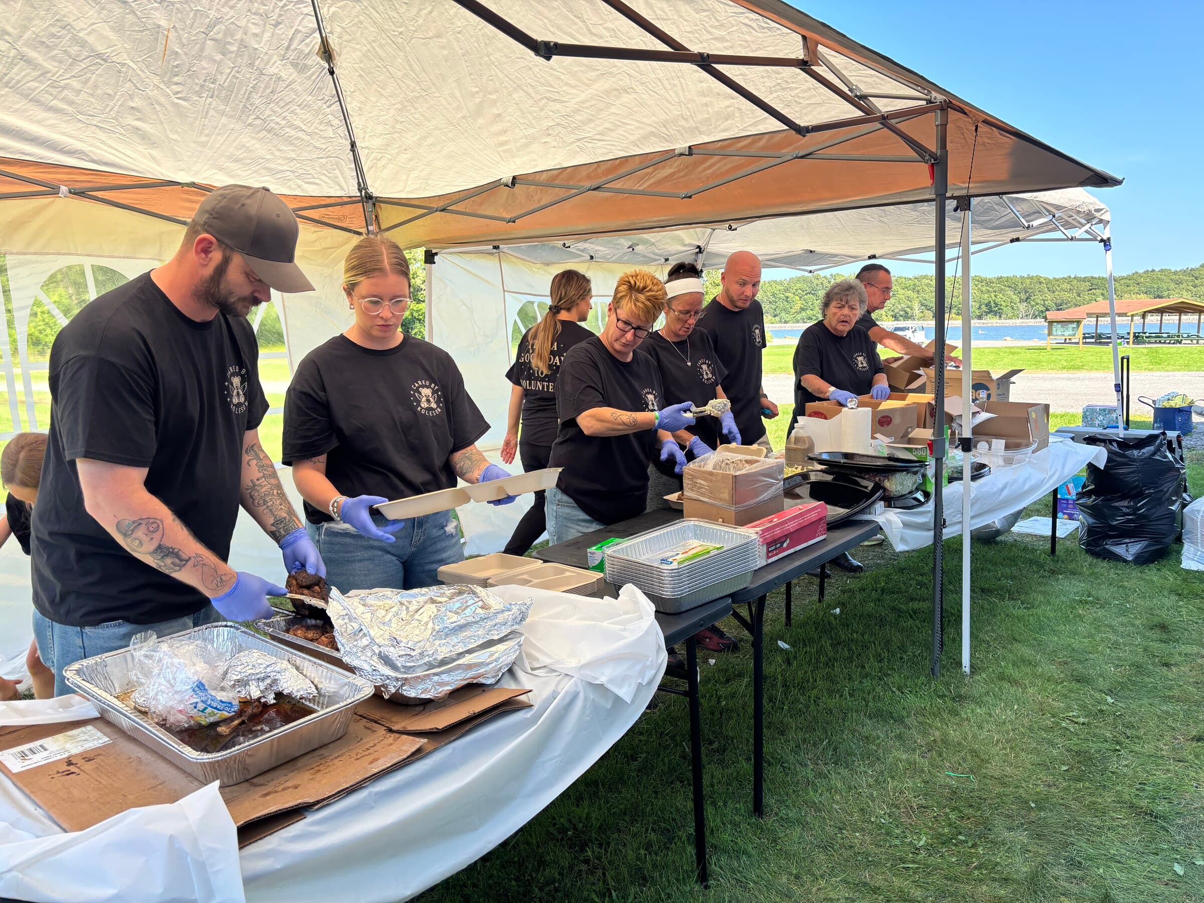 The volunteer line assembling BBQ plates with the lakefront in the background